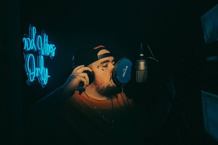 At the mic under cyan neon