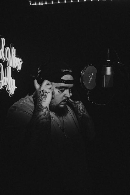 Black and white, head down holding headphones